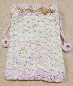 きなり色と薄ピンク色のレース糸で編ん巾着に可愛いお花のアップリケを付けました。（裏に白色の生地を使いました）