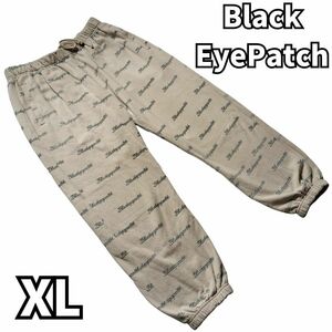 【圧巻のロゴ総柄】　ブラックアイパッチ　BlackEyePatch　シグネチャープリント ジョガーパンツ パンツ スウェット ロゴ 総柄 ベージュ XL